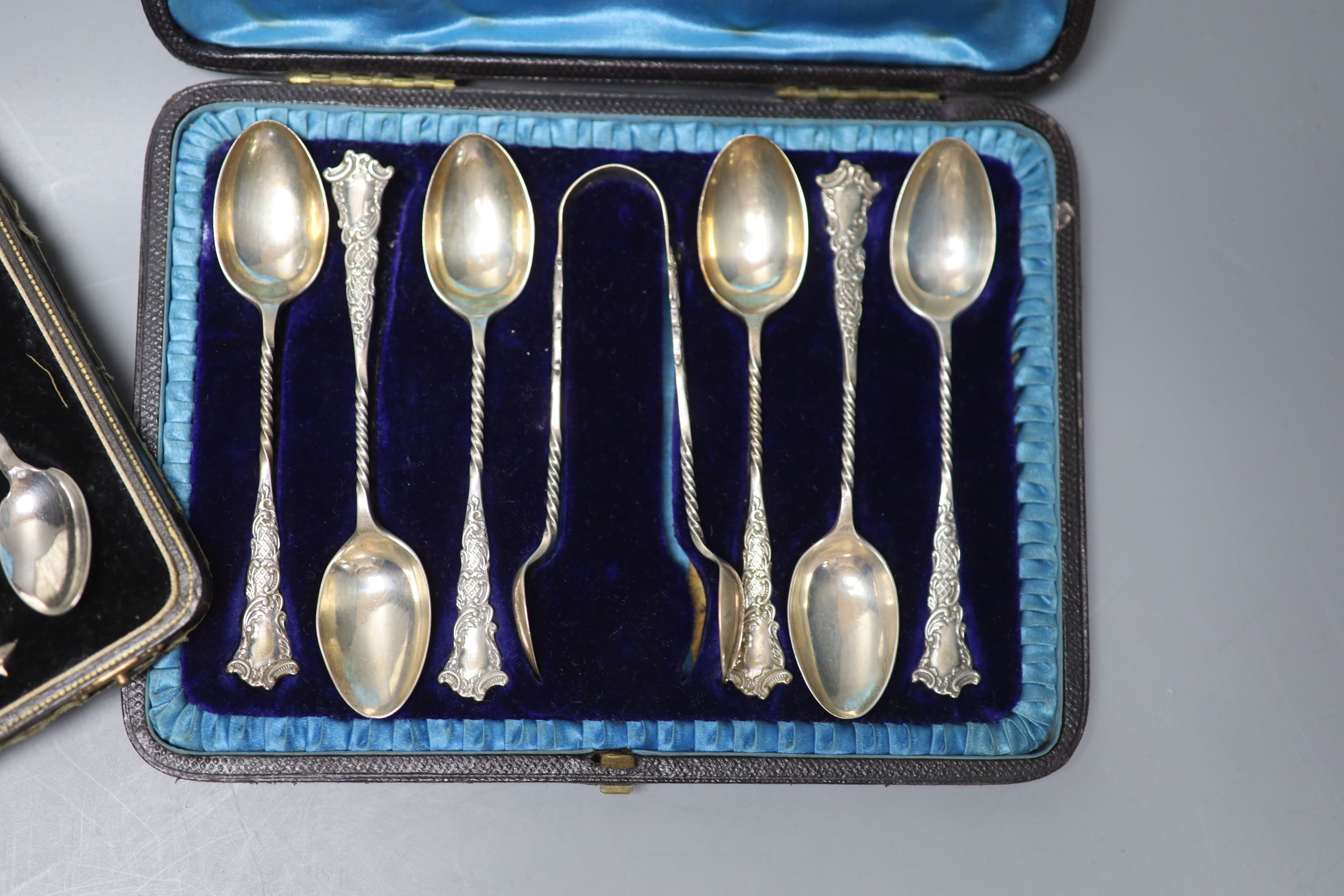 A Victorian cased set of six silver teaspoons with tongs, London, 1897 and a cased set of six white metal teaspoons.